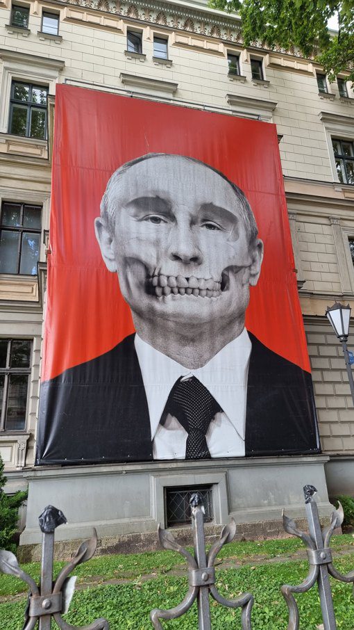 PutinRiga1 Transparent mit Putin , dargestellt als Todesfratze. 2022 aufgenommen in Riga, ein Haus visavis der russischen Botschaft